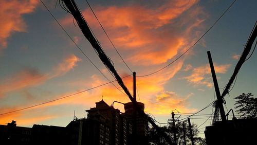 Low angle view of silhouette buildings against dramatic sky