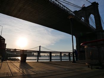 Low angle view of suspension bridges over east river against sky