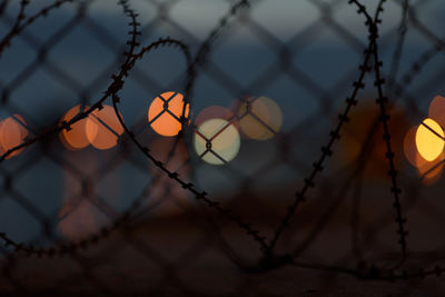 Close-up of chainlink fence during sunset