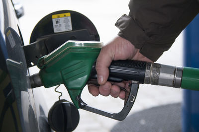 Cropped hand of man refueling car at gas station