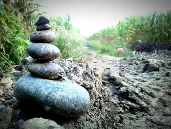 Stack of stones in water against sky