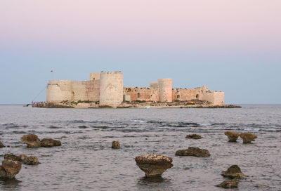 Historic building by sea against clear sky