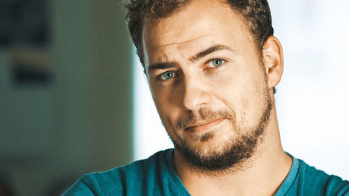 Close-up portrait of smiling young man at home