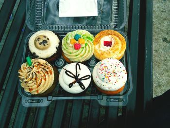 High angle view of cupcakes in plastic container on bench