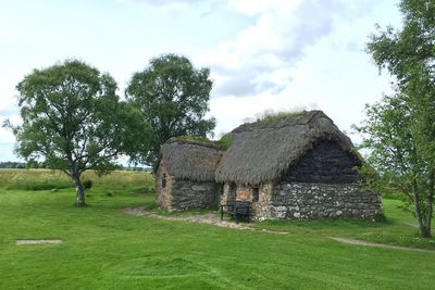 Built structure on grassy field against sky