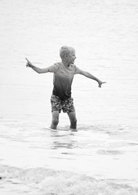 Boy having fun in sea arms outstreched