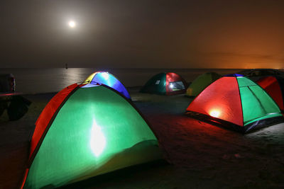 Close-up of illuminated lights against sky at night