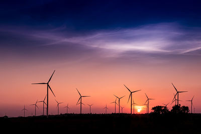 Silhouette of wind turbines at sunset
