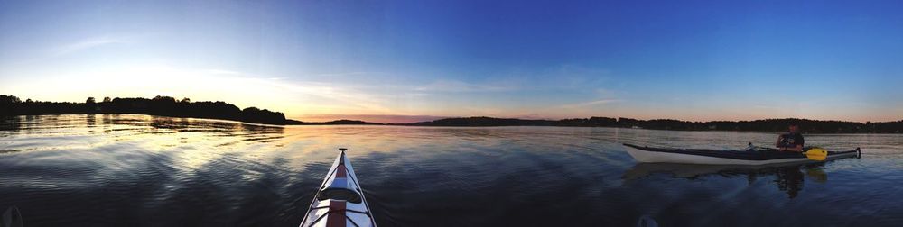 Boats in sea at sunset