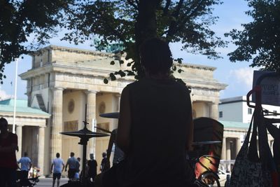 Rear view of people standing in front of building