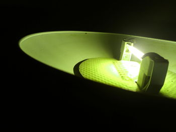 Close-up of illuminated pendant lights over black background