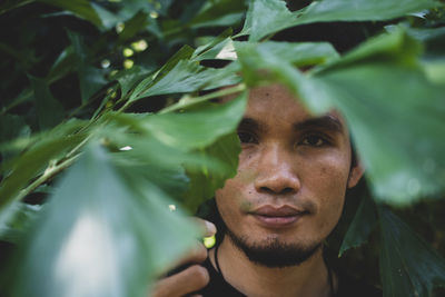 Close-up portrait of man by plants