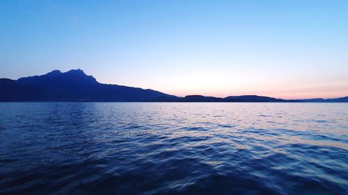 Scenic view of sea and mountains against clear sky