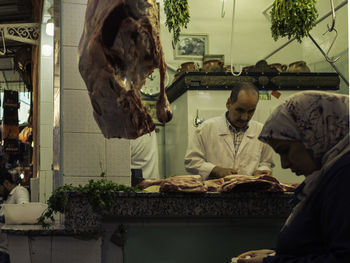 Woman buying meat from butcher in city