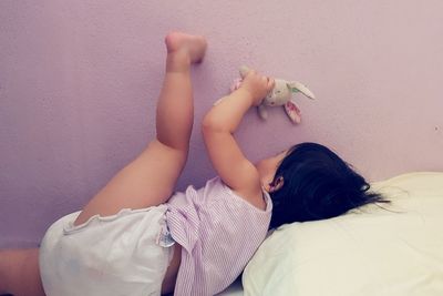 Girl playing with toy against wall at home