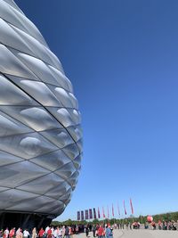 Low angle view of amusement park against clear blue sky