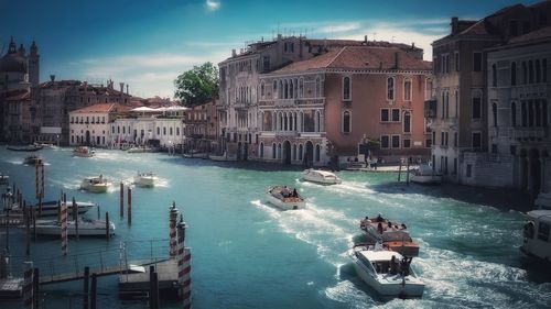 Boats in sea against buildings in city