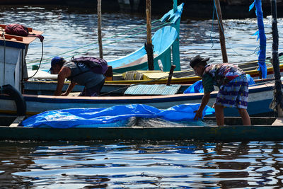 People working in boat at lake