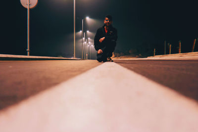 Side view of man on street at night