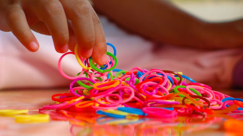 Cropped hand holding multi colored rubber bands