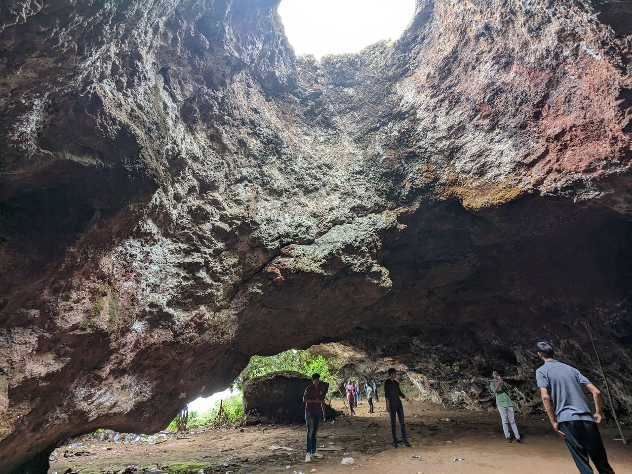 mountain, leisure activity, rock, nature, cave, hiking, men, rock formation, group of people, travel, travel destinations, beauty in nature, adult, adventure, activity, scenics - nature, day, environment, tourism, land, geology, non-urban scene, physical geography, walking, lifestyles, mountain range, landscape, tourist, outdoors, sky, exploration, women, full length, tranquility, wadi, sunlight, outdoor pursuit, vacation, extreme terrain, formation, trip, architecture, holiday, standing