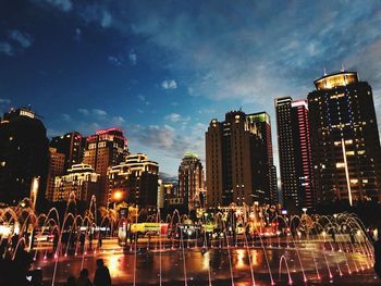 Illuminated buildings in city against sky at night