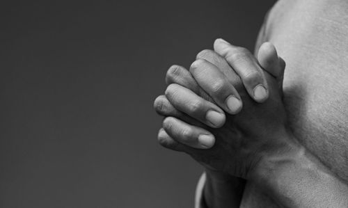 Cropped hand of person against black background