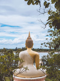 Rear view of buddha statue against sky