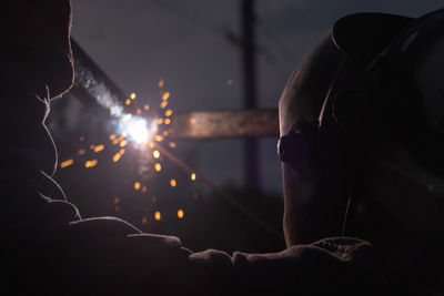 Worker with protective mask welding metal and producing smoke and sparks. arc