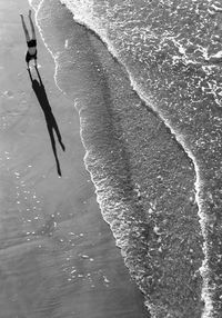 High angle view of man doing handstand at beach