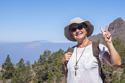 Portrait of smiling woman standing against mountain