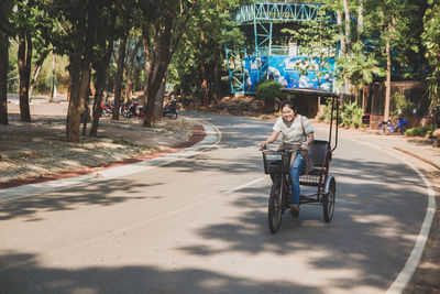 Rear view of man sitting on road