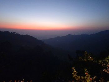 Scenic view of silhouette mountains against sky at sunset