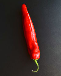 Close-up of red chili peppers against black background