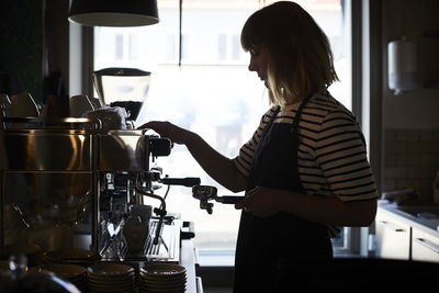 Female barista preparing coffee at cafe