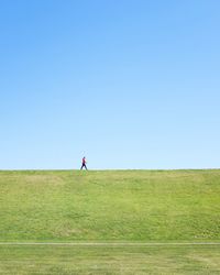 Woman standing on field against clear sky