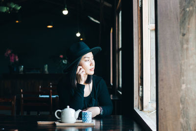 Young woman sitting on table at restaurant