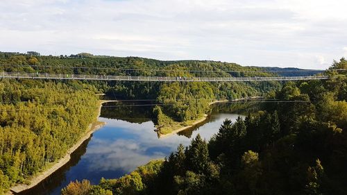 Scenic view of river by trees against sky