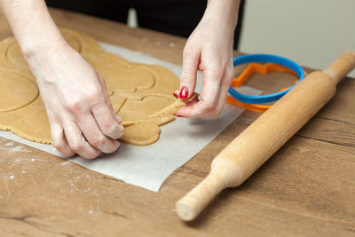 Cropped hands of woman preparing cookies on table