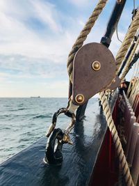 Close-up of padlocks on rope against sea