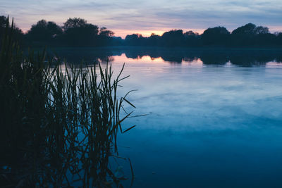 Scenic view of lake against sky at sunset