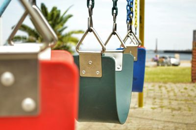 Close-up of swings hanging at playground