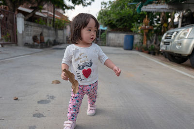 Full length of baby girl walking on road