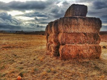 Hay bales on field against sky
