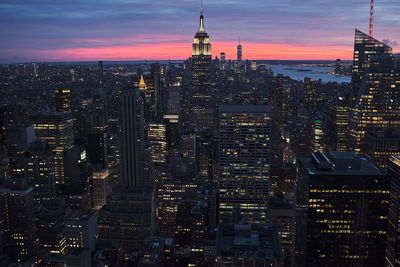 Illuminated buildings in city at dusk