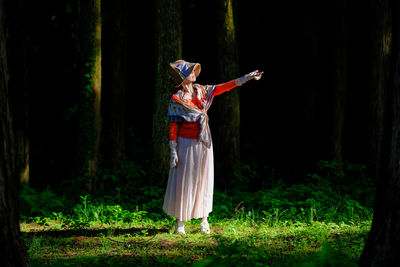 Rear view of woman standing in forest