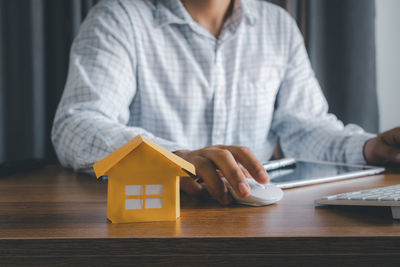 Midsection of woman holding toy while sitting on table