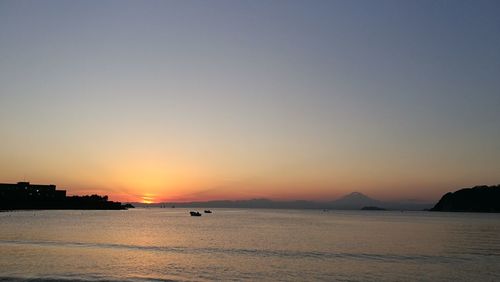 Scenic view of sea against clear sky during sunset