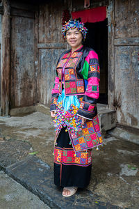 Portrait of woman standing against wall