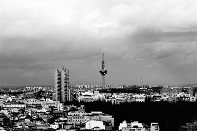 Buildings in city against cloudy sky